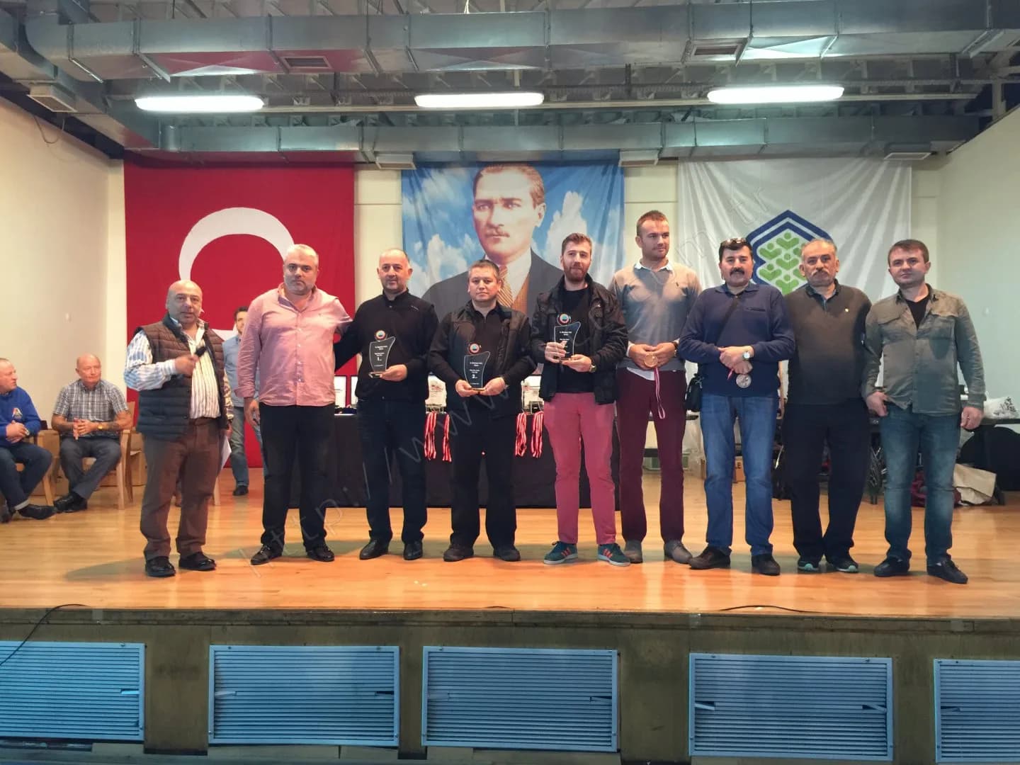 IYCC 2017 ödül töreninde sahnede on kişi; ortada üzerinde 1 ve 2 yazan cam plaketler ve madalyalar