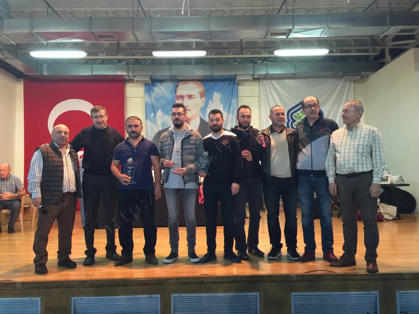 IYCC 2017 ödül töreninde sahnede on kişi; ortadakiler cam plaketlerini, biri madalyasını gösteriyor