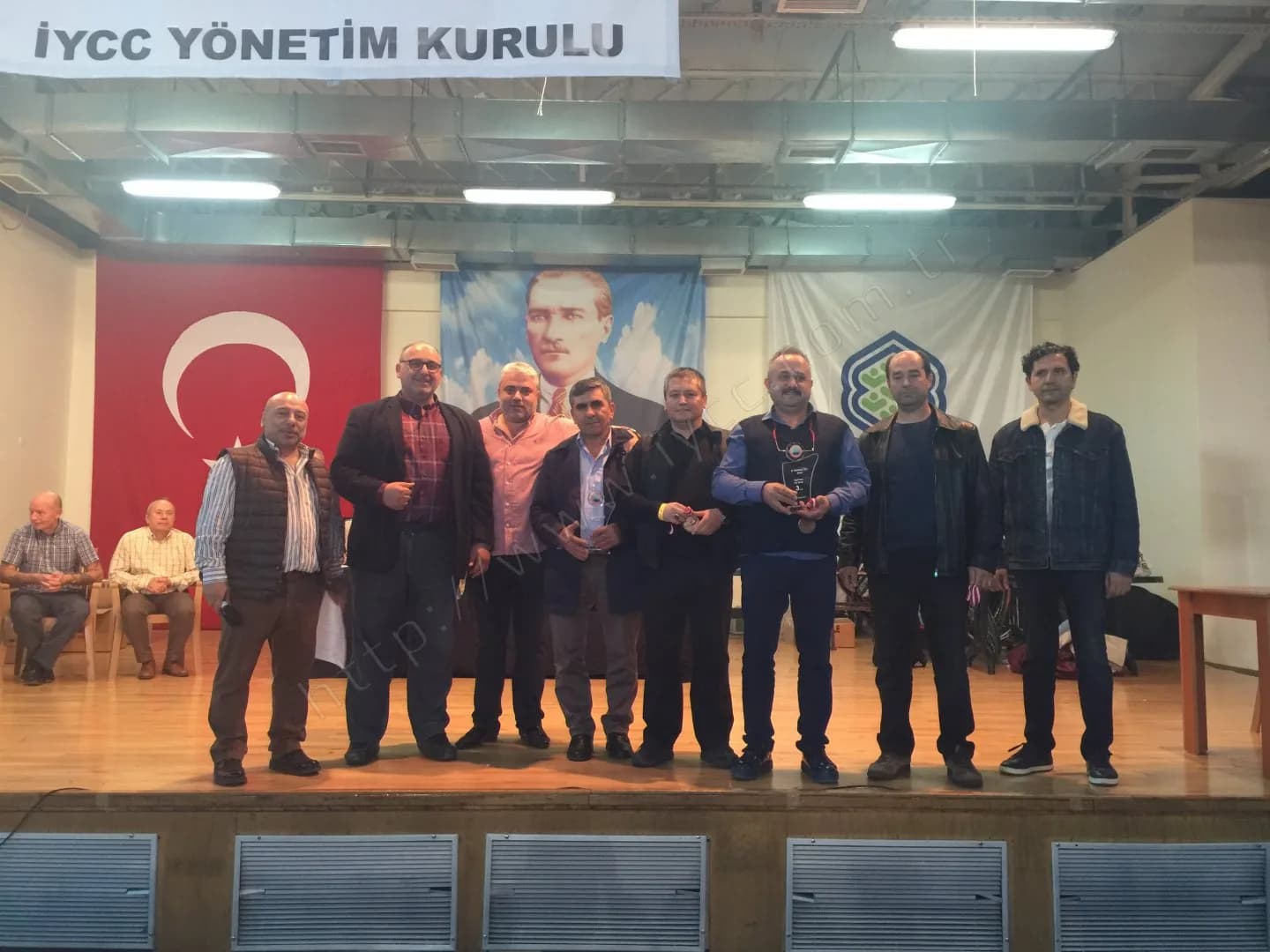 IYCC 2017 ödül töreninde Yönetim Kurulu pankartı altında dokuz kişi, plaket ve madalyalarıyla poz veriyor