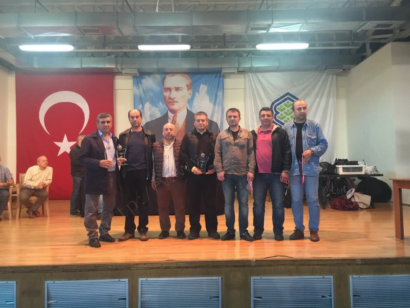 IYCC 2017 ödül töreninde Türk bayrağı ve Atatürk posteri önünde plaket ve madalyalarıyla sekiz kişi