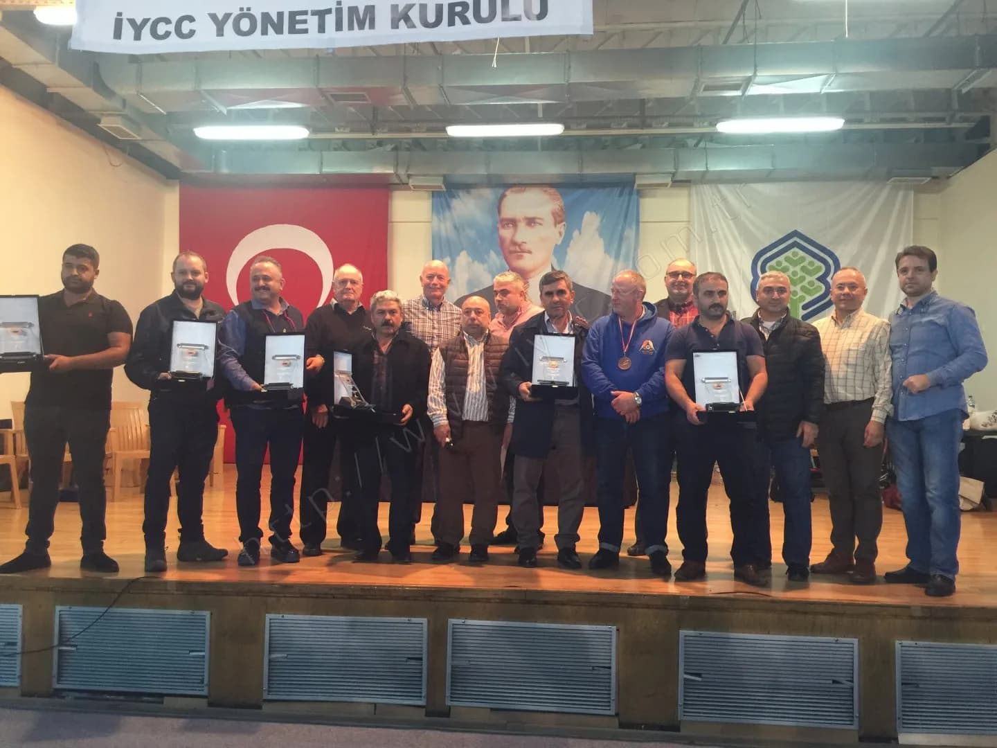 IYCC 2017 ödül töreni sonunda Yönetim Kurulu pankartı altında plaketleriyle sahnede toplanan kalabalık grup