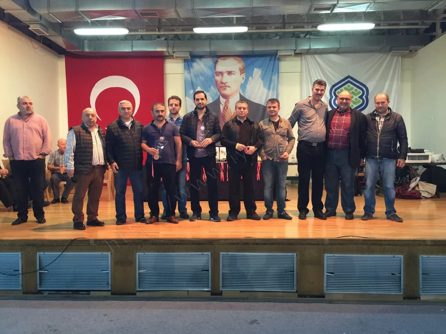 IYCC 2017 ödül töreninde sahnede yan yana duran on bir kişi, ellerinde plaket ve madalyalar