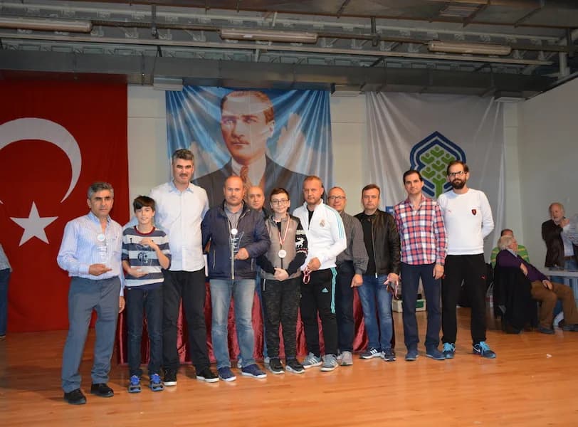 An award group at the IYCC 2018 final that includes two boys, one of them wearing a medal around his neck