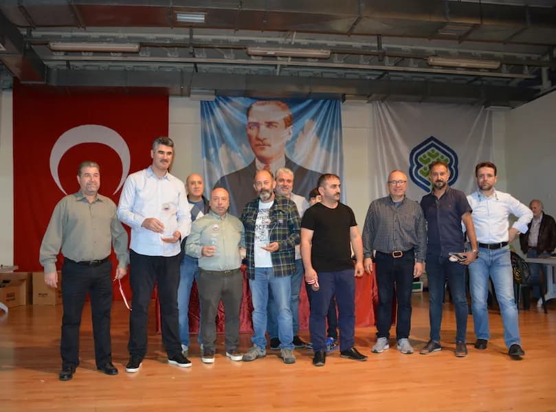 Eleven people with their plaques and medals line up in front of an Atatürk portrait at the IYCC 2018 final