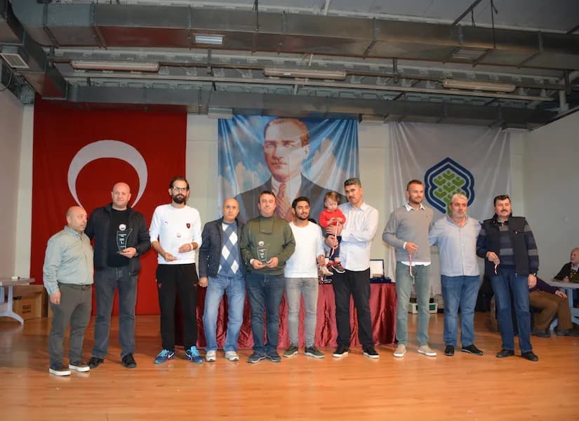 In a group of trophy winners at the IYCC 2018 awards, one man holds a toddler dressed in red in his arms
